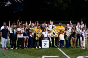 Family, friends and members of the Ballou community gather on the field to honor Terry Bennett, holding candles and standing beside his No. 2 jersey during halftime. Photo courtesy of Ballou High School.